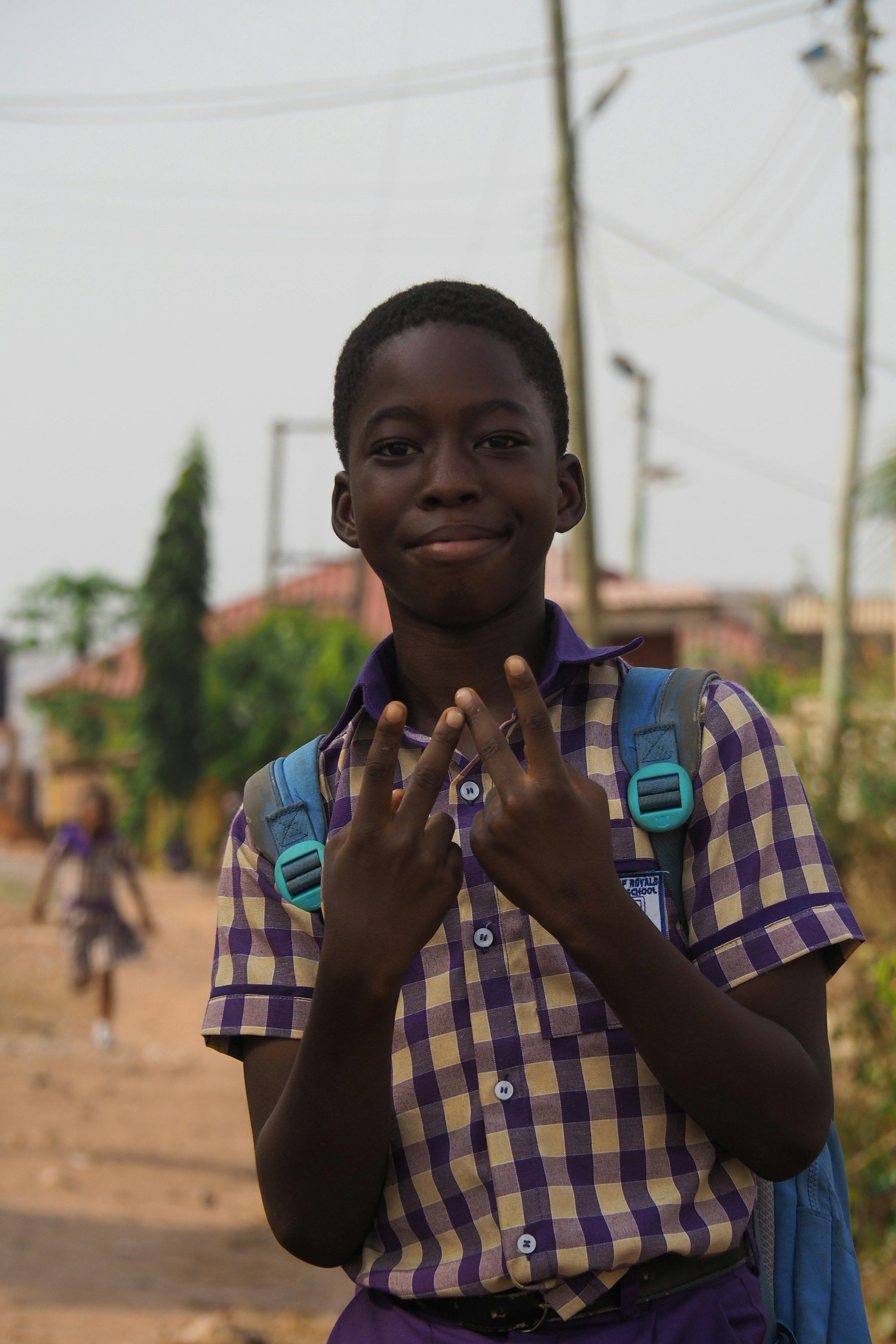 A smiling student gives the peace sign